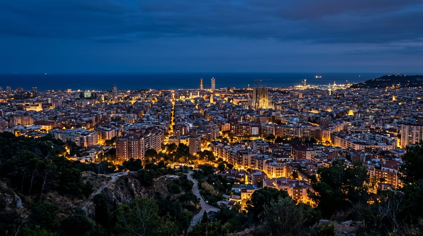 The skyline of Barcelona at blue hour seen from the hills, city lights glowing under a deep blue sky, the sea on the horizon